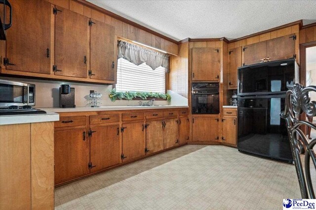 2338 W Mccown Dr, Florence, SC 29501 - kitchen featuring black appliances, brown cabinets, a textured ceiling, a sink, and light countertops