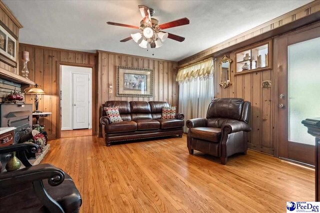 2338 W Mccown Dr, Florence, SC 29501 - living room with ceiling fan, wooden walls, light wood finished floors, and ornamental molding