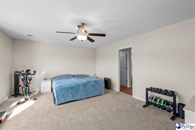 carpeted bedroom with a ceiling fan, visible vents, and baseboards