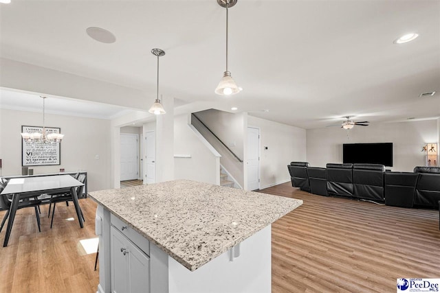 kitchen featuring light wood-style floors, open floor plan, visible vents, and hanging light fixtures