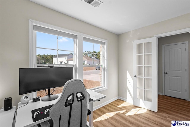 office with wood finished floors, visible vents, and baseboards