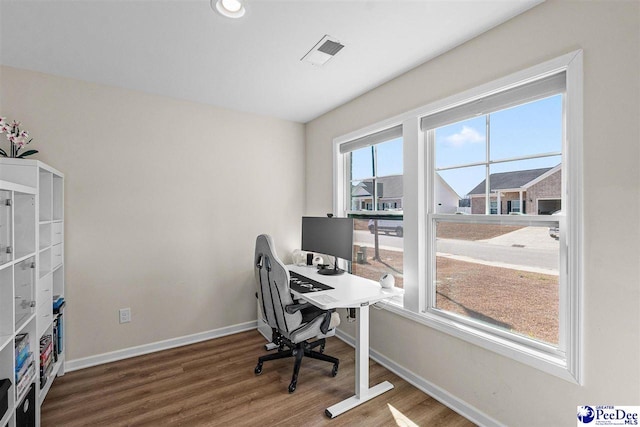 office with baseboards, visible vents, and wood finished floors