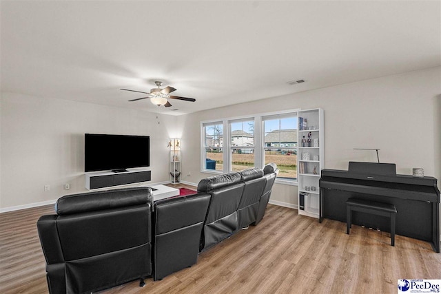 living room featuring light wood-style floors, visible vents, and baseboards