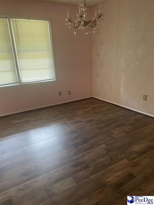 108 Swails St, Kingstree, SC 29556 - spare room featuring dark wood-style floors, a chandelier, and baseboards
