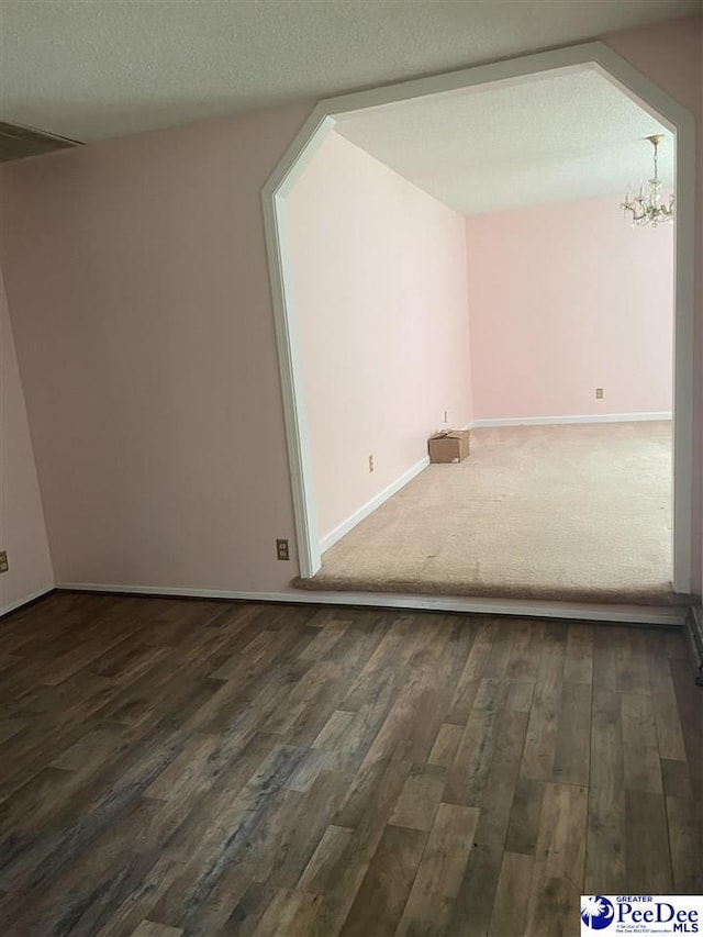108 Swails St, Kingstree, SC 29556 - bonus room featuring a chandelier, dark wood-style flooring, baseboards, and a textured ceiling