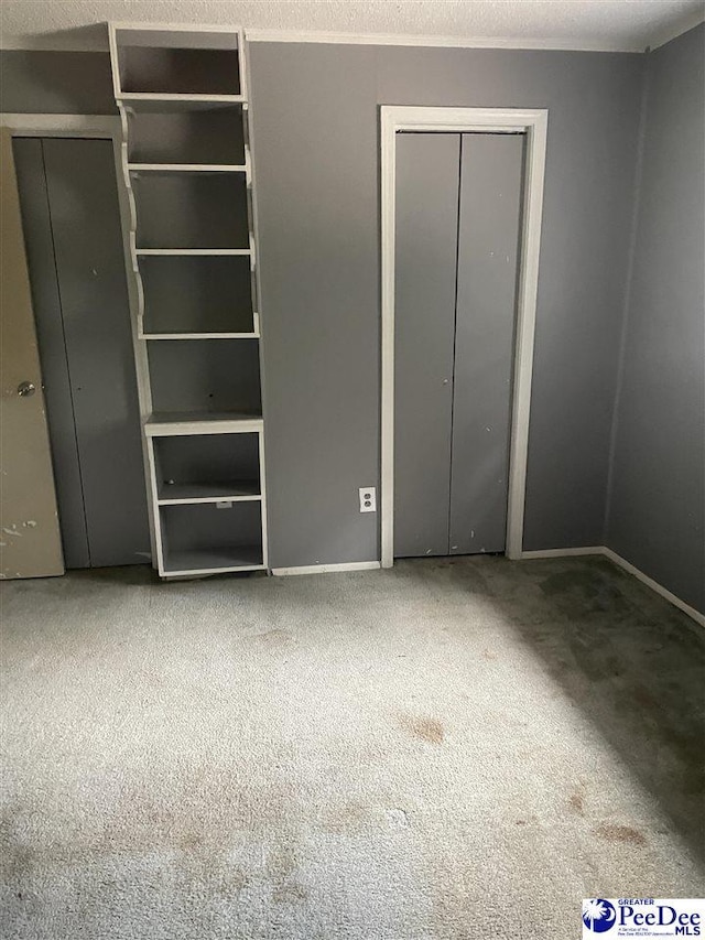 108 Swails St, Kingstree, SC 29556 - unfurnished bedroom featuring carpet flooring, baseboards, and two closets