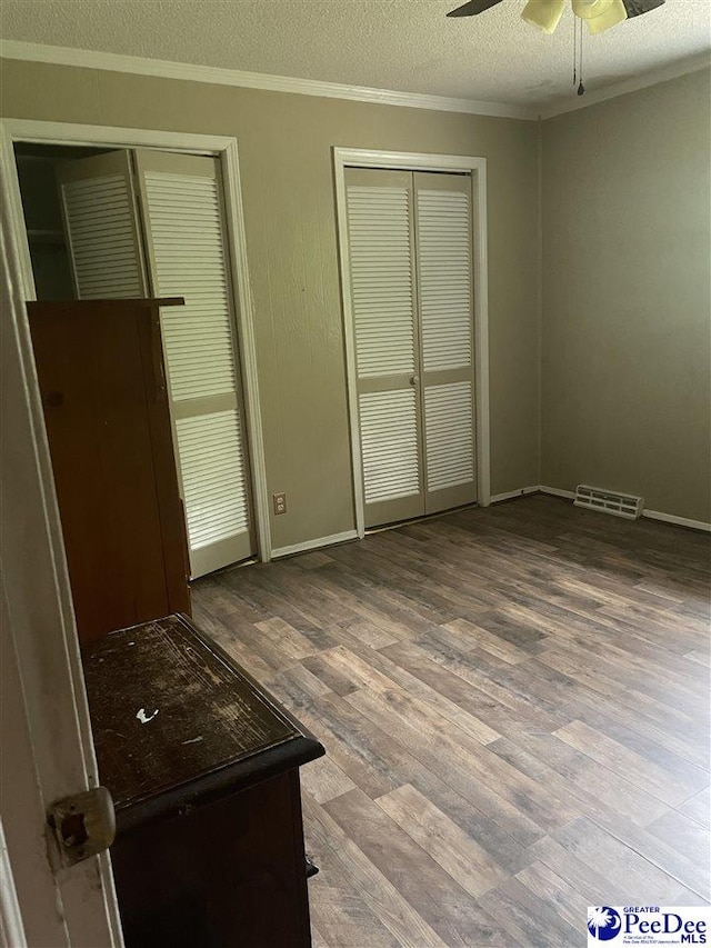 108 Swails St, Kingstree, SC 29556 - unfurnished bedroom with crown molding, wood finished floors, a textured ceiling, two closets, and baseboards