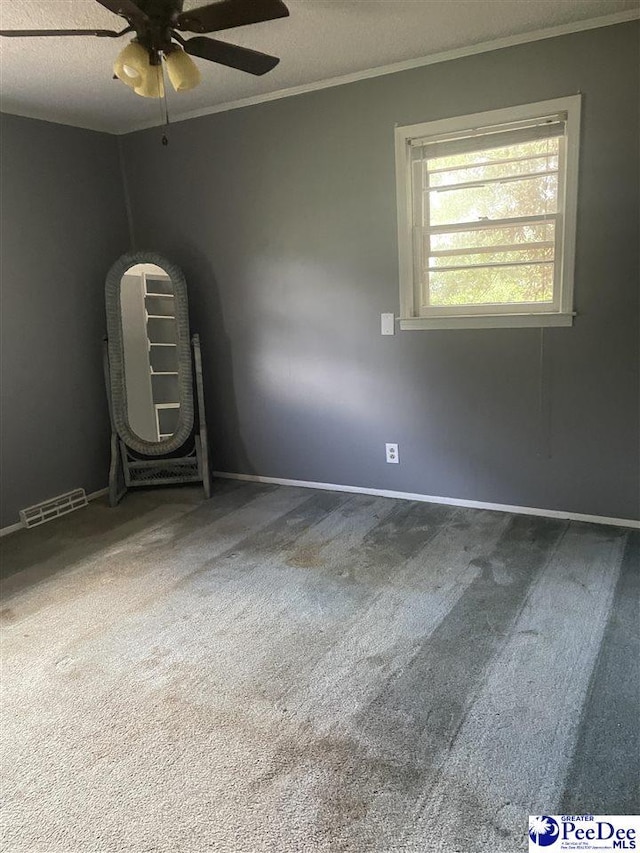 108 Swails St, Kingstree, SC 29556 - empty room with crown molding, ceiling fan, carpet flooring, baseboards, and a textured ceiling