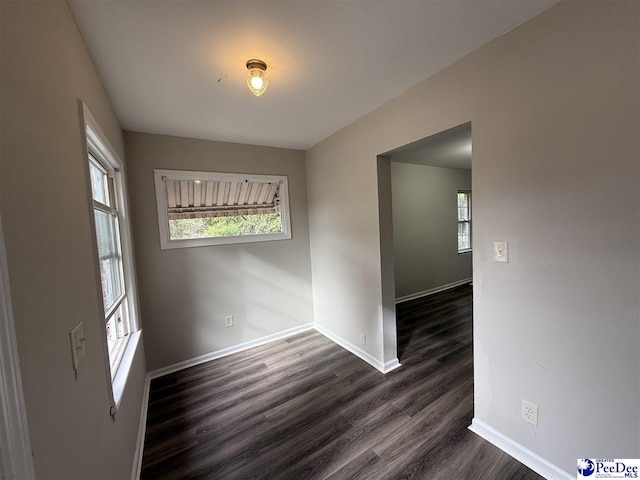 empty room with dark hardwood / wood-style flooring