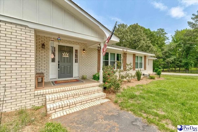 133 Peacock Row, Lamar, SC 29069 - doorway to property with brick siding and board and batten siding