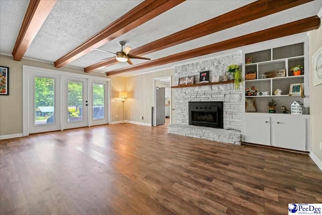 133 Peacock Row, Lamar, SC 29069 - unfurnished living room featuring wood finished floors, ceiling fan, baseboards, beamed ceiling, and a stone fireplace