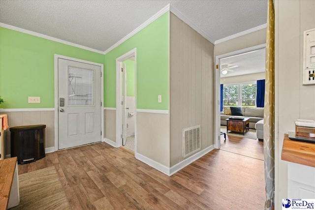133 Peacock Row, Lamar, SC 29069 - foyer with wood finished floors, ornamental molding, a textured ceiling, wooden walls, and wainscoting