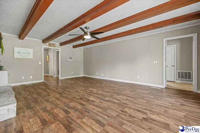 133 Peacock Row, Lamar, SC 29069 - unfurnished living room with wood finished floors, a ceiling fan, beamed ceiling, baseboards, and a textured ceiling