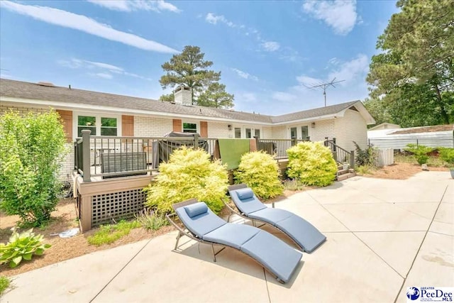 133 Peacock Row, Lamar, SC 29069 - back of property featuring a patio area, a deck, a chimney, and brick siding