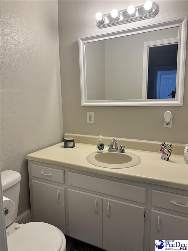 half bathroom with toilet and vanity