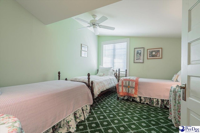 bedroom with ceiling fan, lofted ceiling, and dark colored carpet