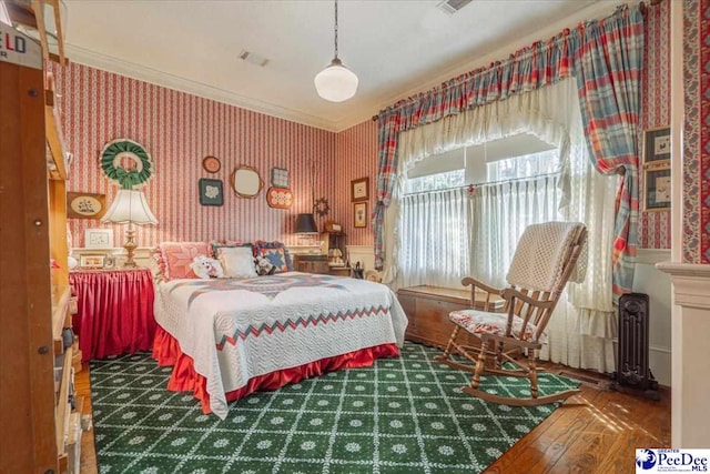 bedroom with ornamental molding and dark hardwood / wood-style flooring