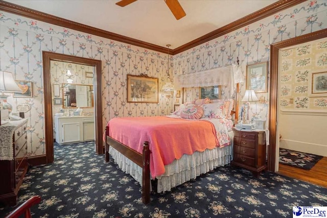 bedroom featuring crown molding, ceiling fan, ensuite bathroom, and dark colored carpet