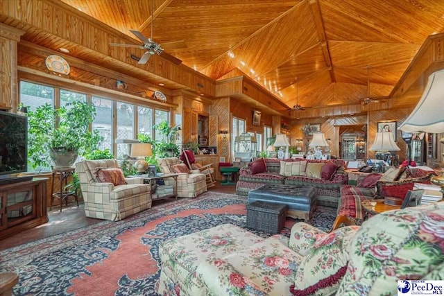 living room featuring ceiling fan, high vaulted ceiling, and wood walls