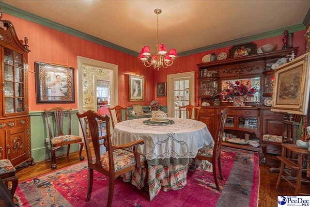 dining space featuring an inviting chandelier, ornamental molding, and wood-type flooring