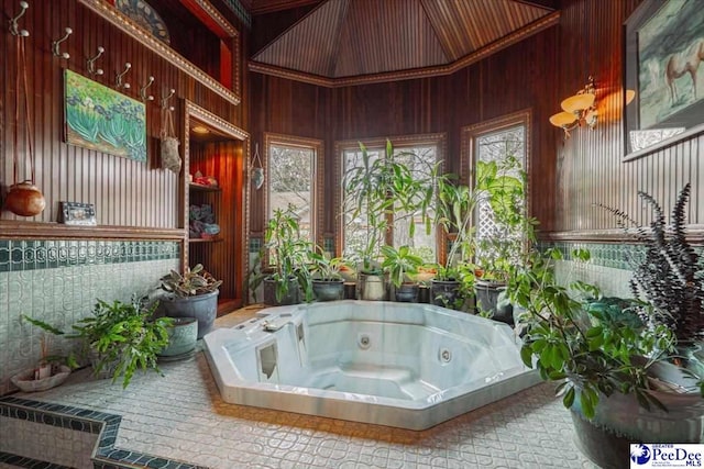 bathroom with a relaxing tiled tub and wooden walls