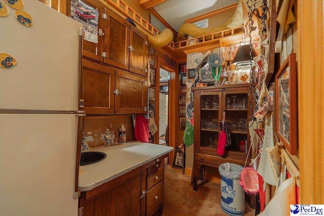 kitchen with white fridge and dark carpet