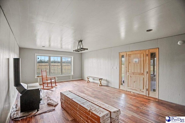 living area featuring a wood stove and hardwood / wood-style flooring