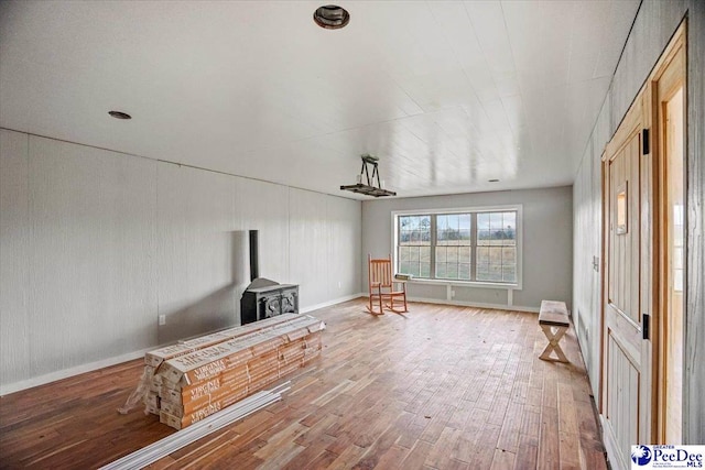 interior space featuring hardwood / wood-style flooring, baseboards, and a wood stove
