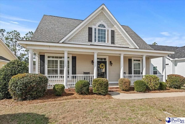 view of front of property with a porch and a shingled roof