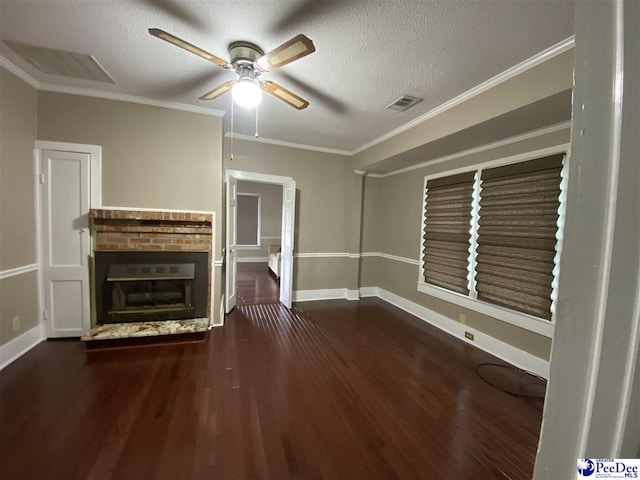 unfurnished living room with ceiling fan, a brick fireplace, crown molding, and wood finished floors