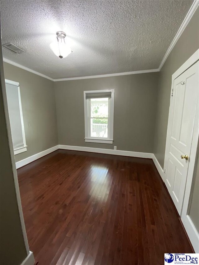 202 S Warley St, Darlington, SC 29532 - unfurnished room featuring dark wood-style floors, a textured ceiling, crown molding, and baseboards