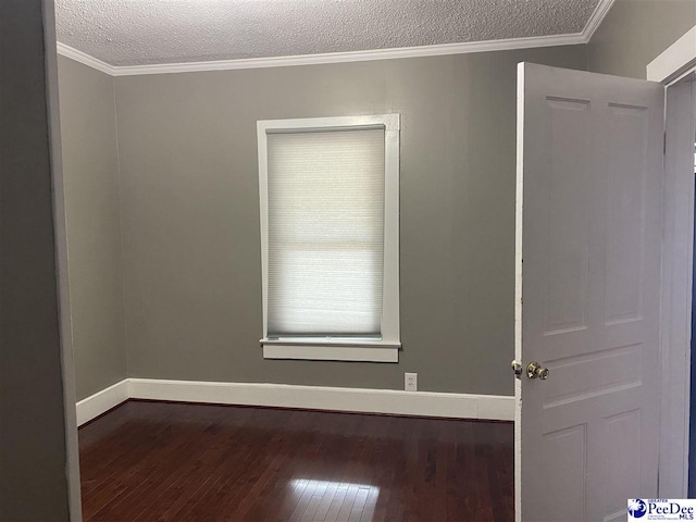 unfurnished room with dark wood-type flooring, ornamental molding, a textured ceiling, and baseboards