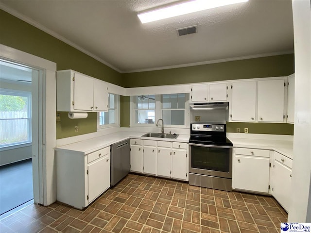 kitchen with crown molding, brick patterned floor, appliances with stainless steel finishes, a sink, and under cabinet range hood