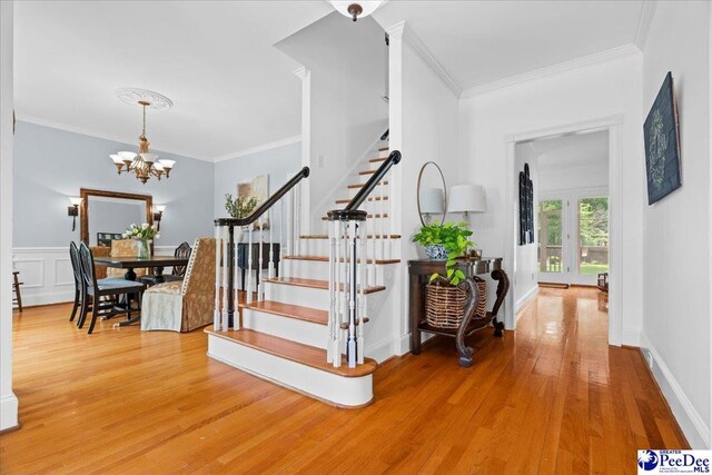 3402 Sussex Ct, Florence, SC 29501 - stairs featuring wood finished floors, ornamental molding, and a chandelier