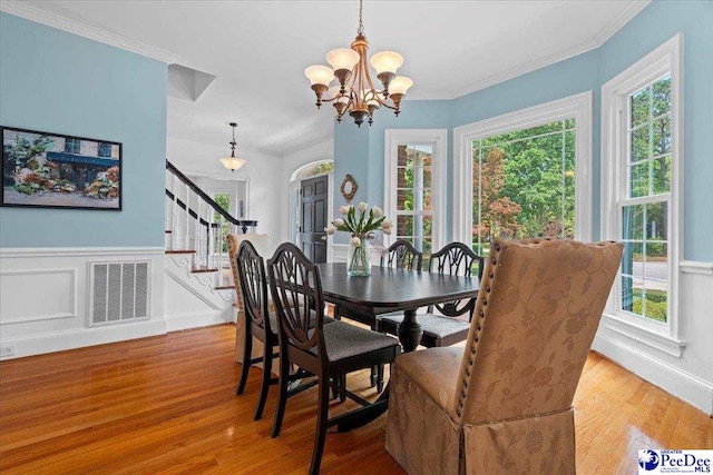 3402 Sussex Ct, Florence, SC 29501 - dining area with stairs, wood finished floors, a chandelier, plenty of natural light, and wainscoting