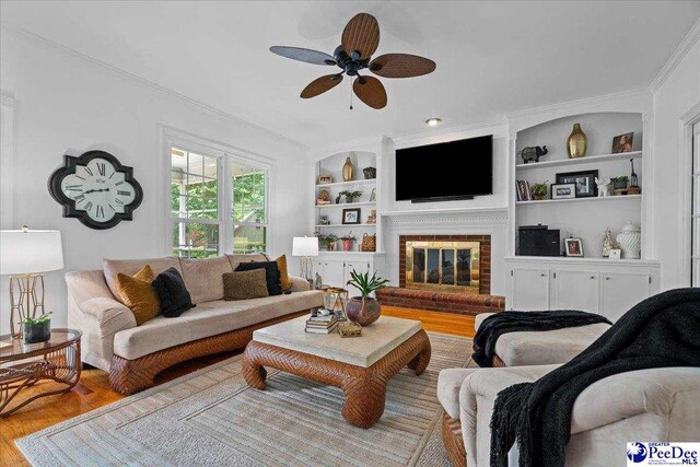 3402 Sussex Ct, Florence, SC 29501 - living area with wood finished floors, a ceiling fan, crown molding, a fireplace, and built in shelves