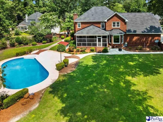 3402 Sussex Ct, Florence, SC 29501 - rear view of property with a sunroom, a chimney, a patio area, an outdoor pool, and a lawn