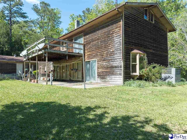 2305 Sandra Cir, Palmplico, SC 29583 - rear view of property with a deck, a yard, a patio, and a chimney