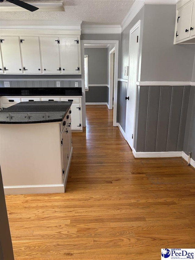 111 Brittain Rd, Darlington, SC 29532 - kitchen with white cabinetry, crown molding, dark countertops, light wood-type flooring, and a textured ceiling