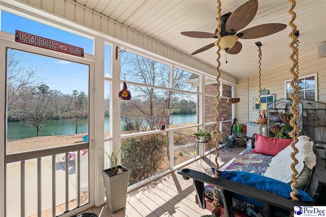 sunroom featuring plenty of natural light, ceiling fan, a water view, and wood ceiling