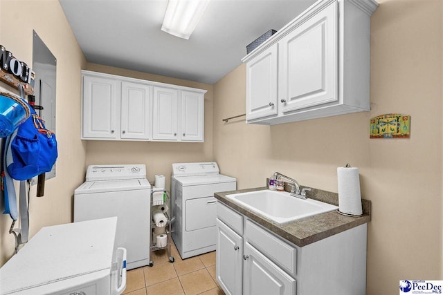 clothes washing area with light tile patterned floors, independent washer and dryer, a sink, and cabinet space
