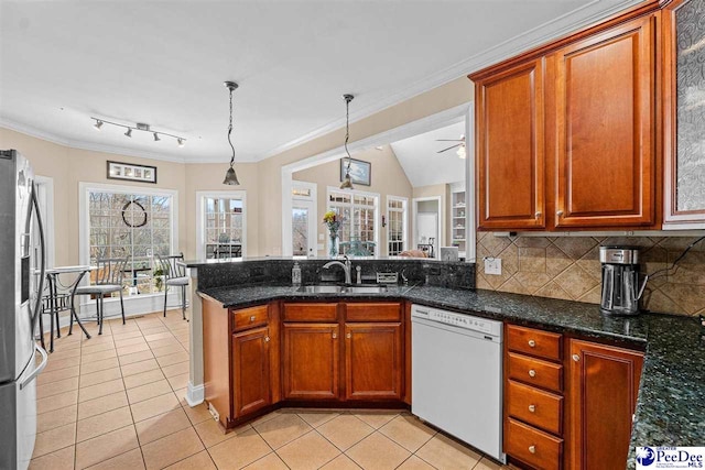kitchen with stainless steel refrigerator with ice dispenser, tasteful backsplash, a sink, dishwasher, and a peninsula