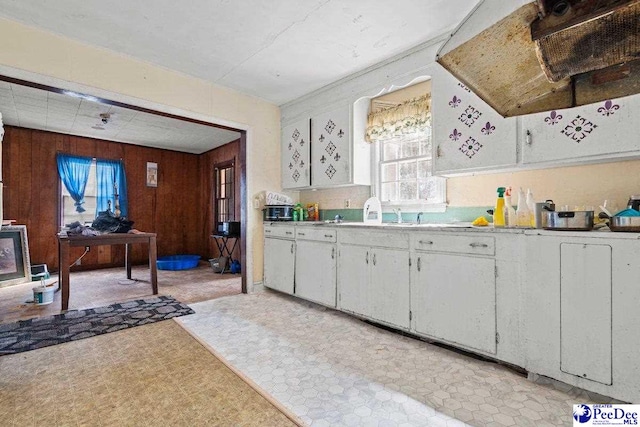 517 Alane St, Lake City, SC 29560 - kitchen with light countertops, a sink, wood walls, light floors, and white cabinets