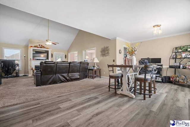 dining space with lofted ceiling, ornamental molding, and light hardwood / wood-style floors