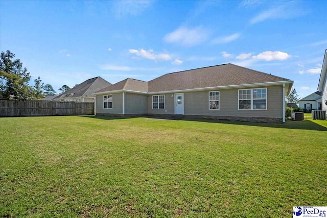 rear view of house featuring a yard and central air condition unit