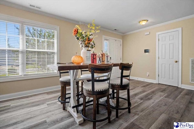 dining room featuring wood-type flooring and ornamental molding