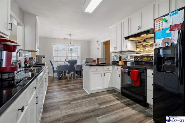 kitchen with dark wood-type flooring, white cabinets, kitchen peninsula, and black appliances