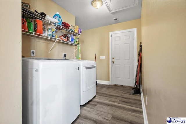 clothes washing area with wood-type flooring and washing machine and dryer