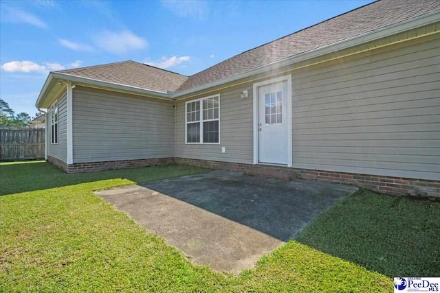 rear view of house with a yard and a patio area