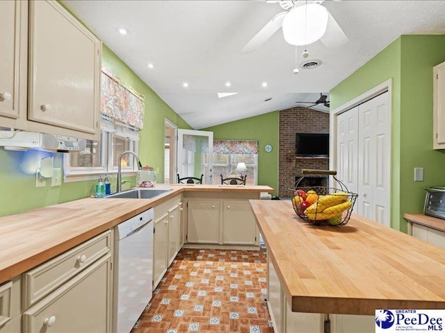 kitchen featuring sink, butcher block countertops, dishwasher, a fireplace, and cream cabinets